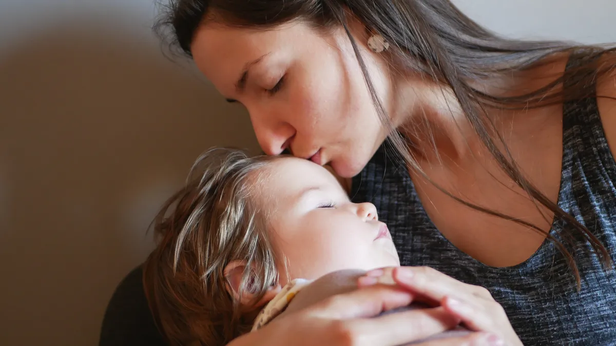 Madre abrazando con ternura a su bebé, fortaleciendo el apego