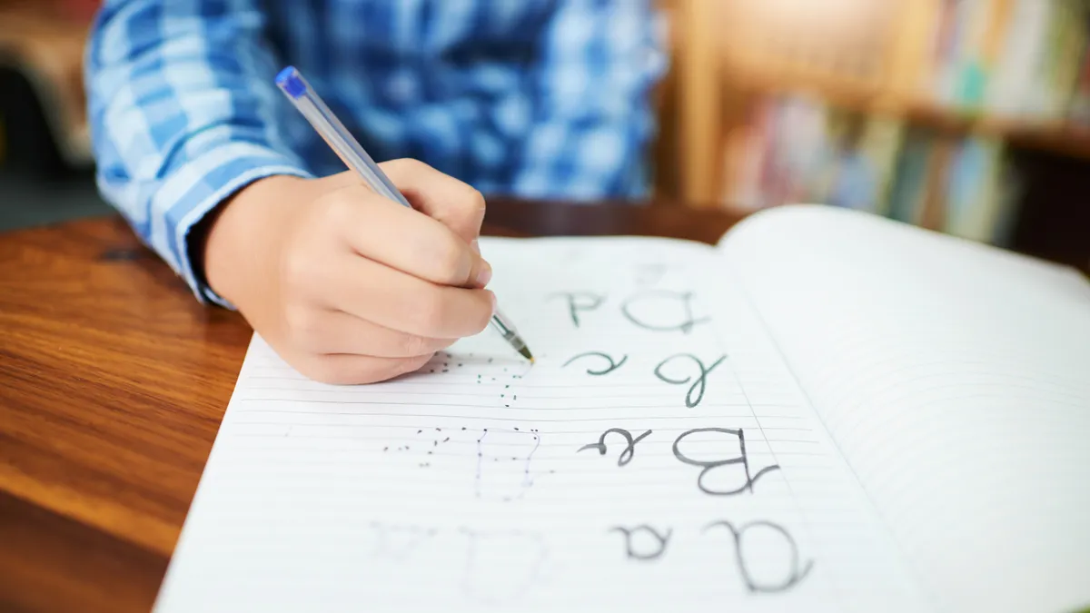 Niño practicando trazos y letras, desarrollo de la lectoescritura