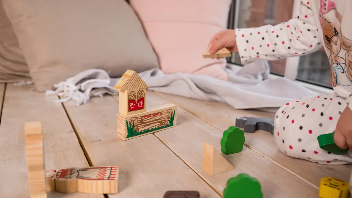 Niño concentrado con materiales Montessori de madera en casa