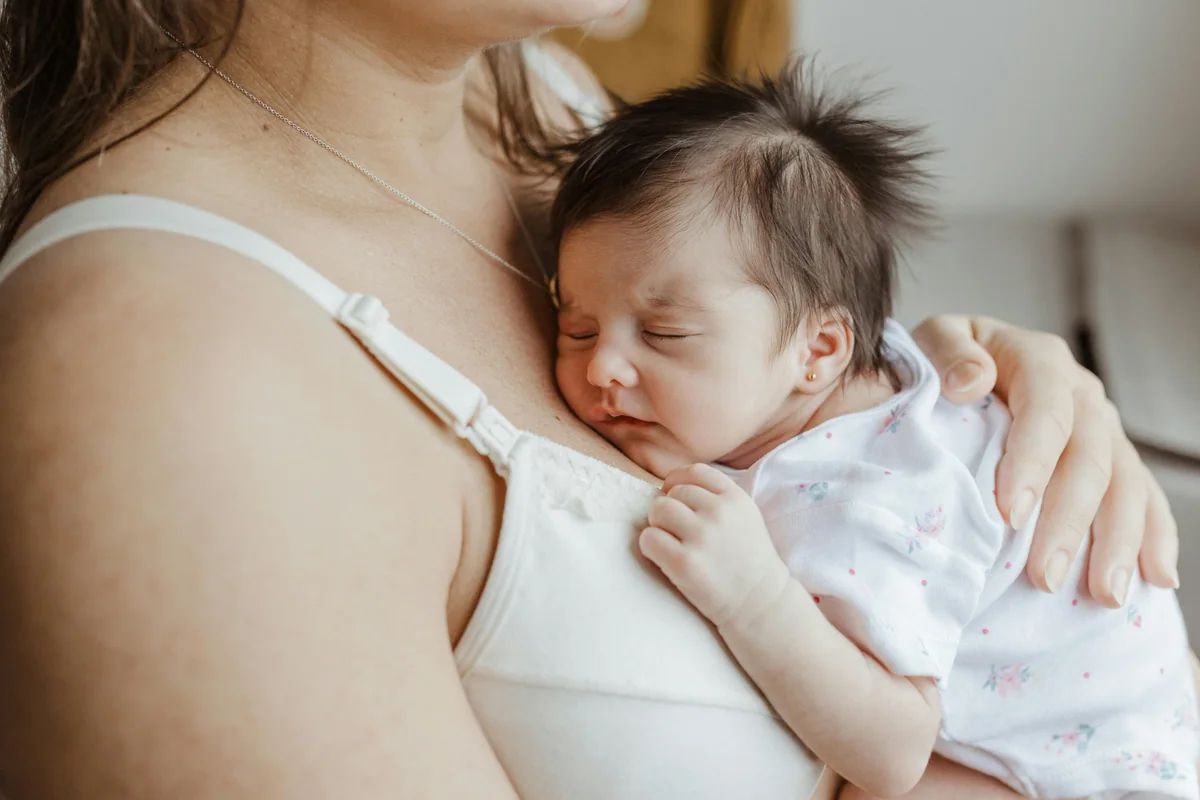 Madre leyendo un cuento en voz alta acompañada por su bebé